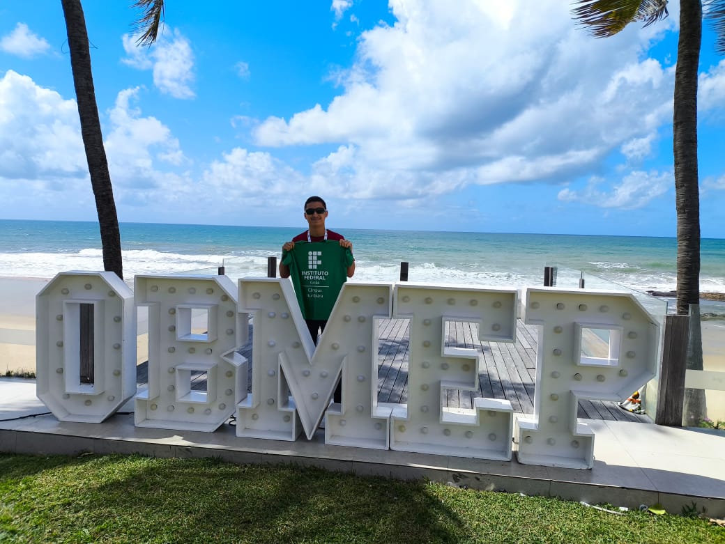 Davi posa para a foto com uma camiseta do Câmpus Itumbiara